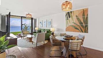 Una sala de estar moderna con comedor, ventanas amplias y vista al mar.