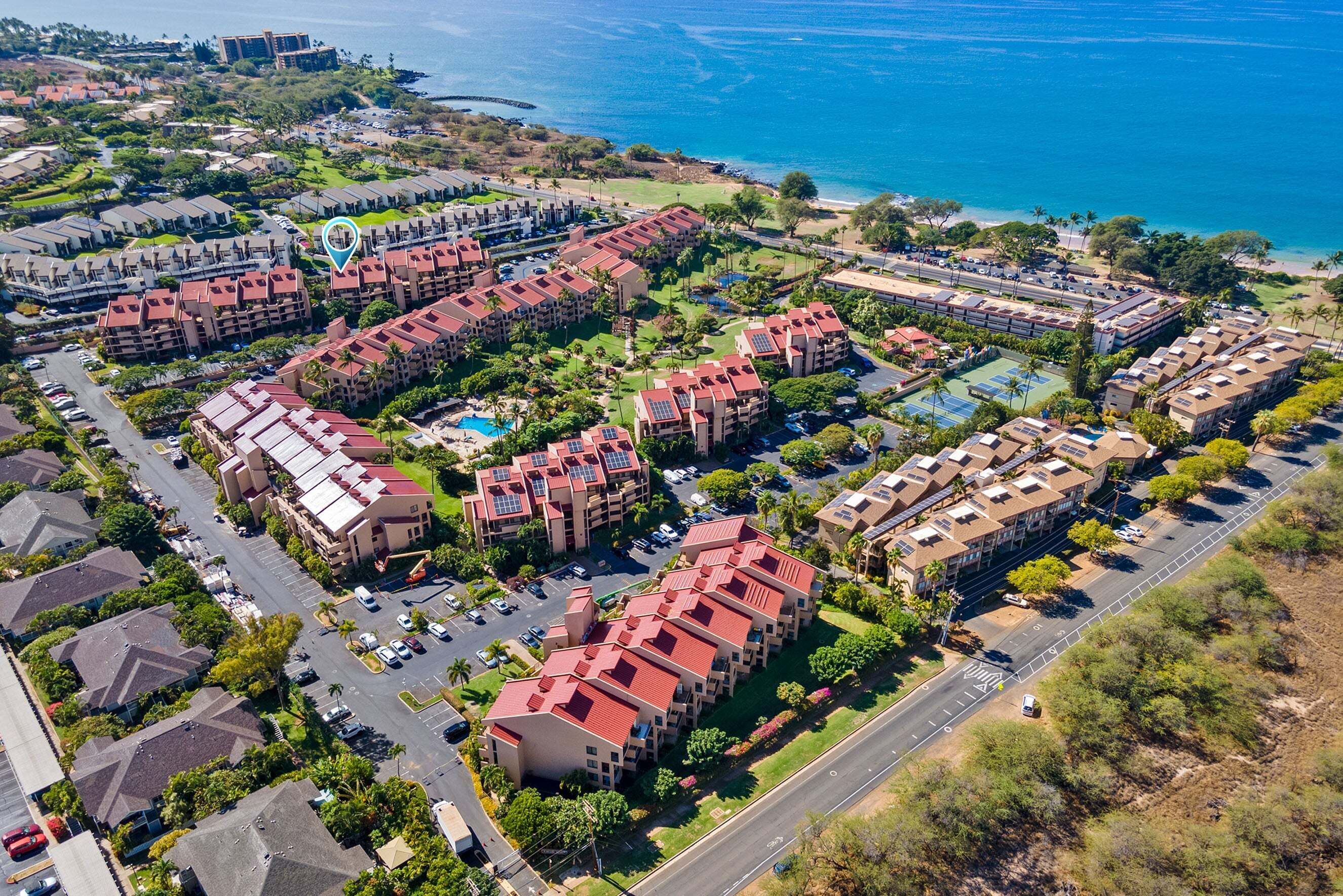 Zona residencial costera con varios edificios de apartamentos, calles y una playa.