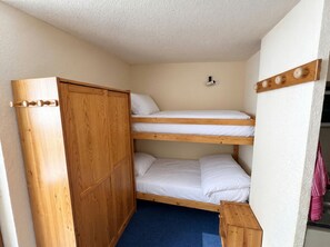 A bunk bed room with a wooden wardrobe and a small bedside table. - (CD-1304) Val Thorens - Ski In/Out - 5 Beds Flat (Les Belleville)