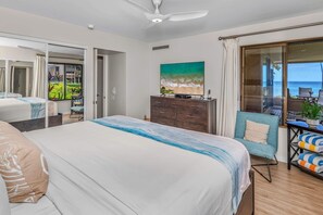 A bedroom with a bed, a dresser, a painting, and a view of the ocean through a glass door. - Luxurious Oceanfront Condo at Wailea Elua Village - Unit 1201, Central AC, Wi-fi (Kihei)
