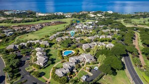 Eine Luftaufnahme eines Wohngebiets mit Golfplatz, Schwimmbad und Häusern direkt am Strand.