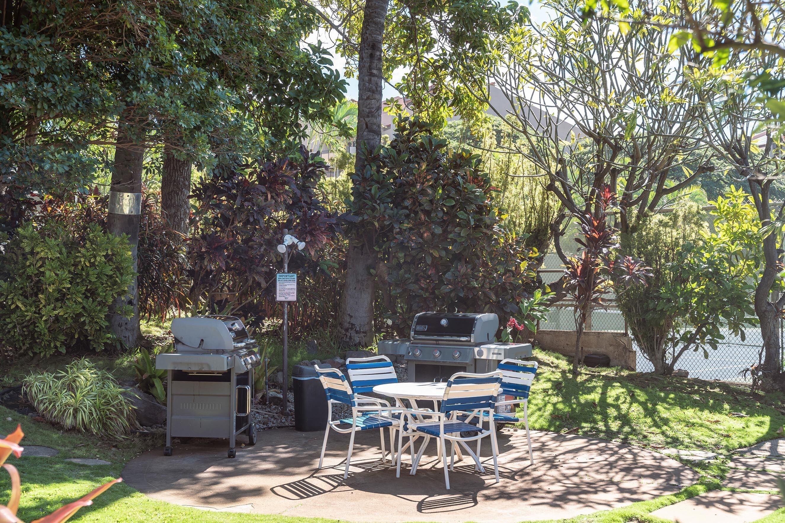 Eine Außenpatio mit Grill, Stühlen und Tisch.
