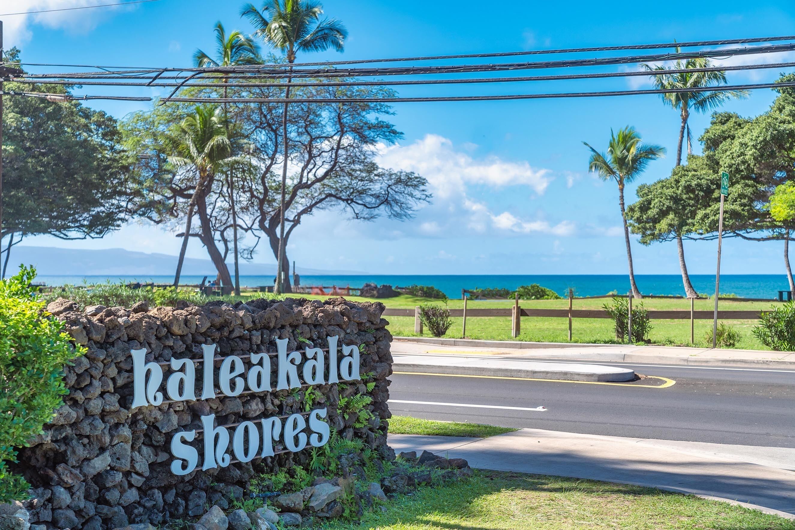 Un panneau indiquant « Kaleakala Shores », avec une vue sur l’océan et les palmiers.