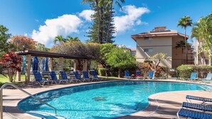 A swimming pool with lounge chairs, a pergola, and palm trees. - Haleakala Shores A-301 - Golden Sand Beaches, Ocean Views, Sleeps 6, Split AC! (Kihei)