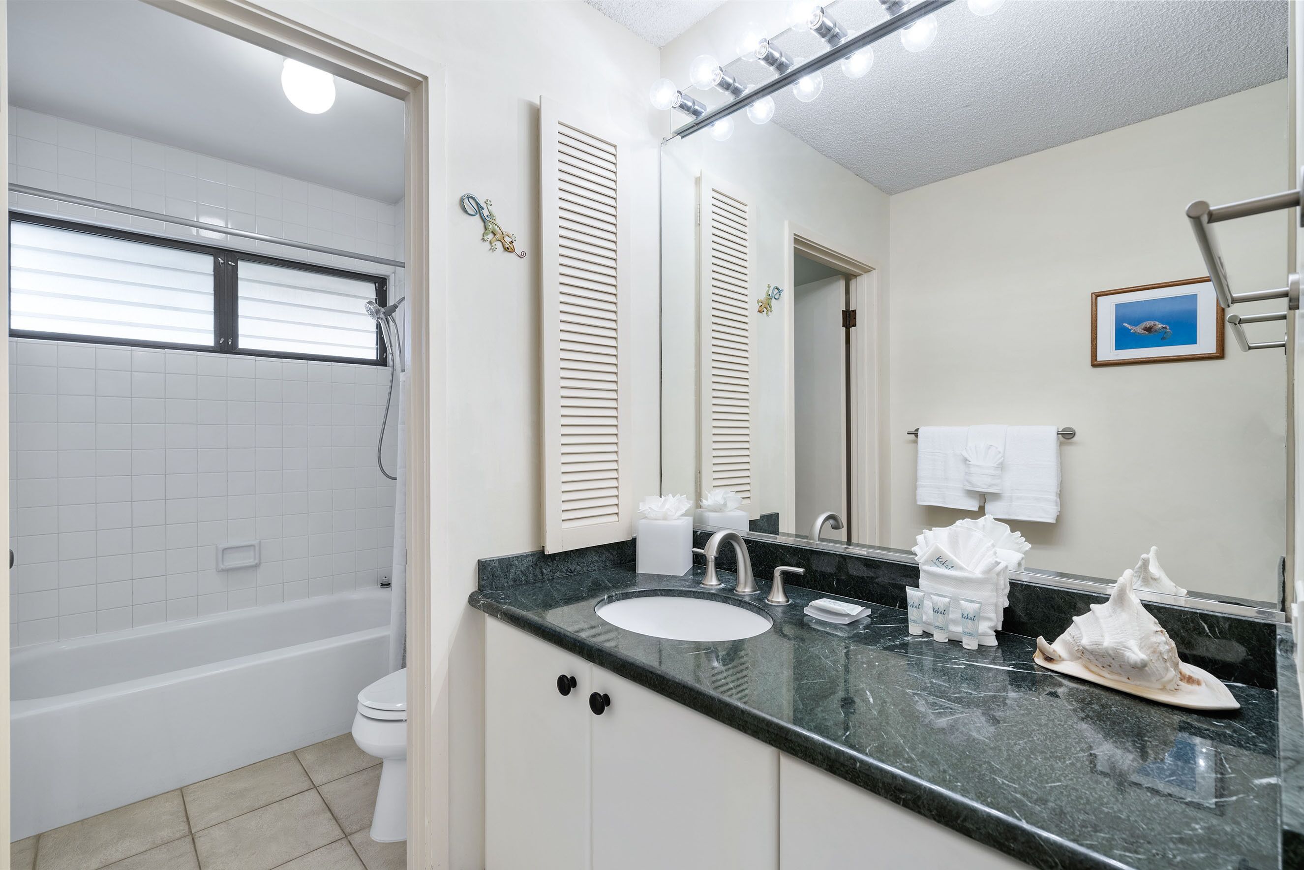 Une salle de bain avec une baignoire, des toilettes, un lavabo et un grand miroir.