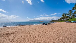 A beach with sand, a clear sky, and a distant mountain. - Wailea Ekahi 20J - Secluded Garden Oasis Surrounded by Trees & Tropical Blooms (Kihei)