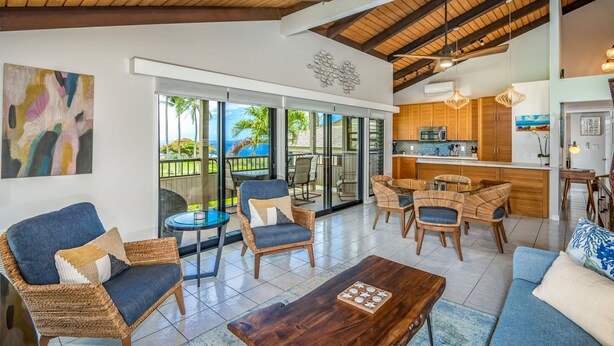 A spacious living area with wicker furniture, a wooden coffee table, and a view of the outdoors. - Wailea Ekolu 1204 - Modern Ocean View Condo w/ Large Lanai, King Bed, & Split AC (Kihei)