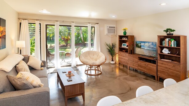 Una sala de estar moderna con un sofá, una mesa de centro y un mueble de entretenimiento de madera.