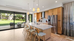 A modern kitchen with a large island, stainless steel appliances, and wooden cabinets. - New Listing! Honua Kai Luana Garden Villas 7B - Ground Level, Private Lanai, BBQ (Lahaina)