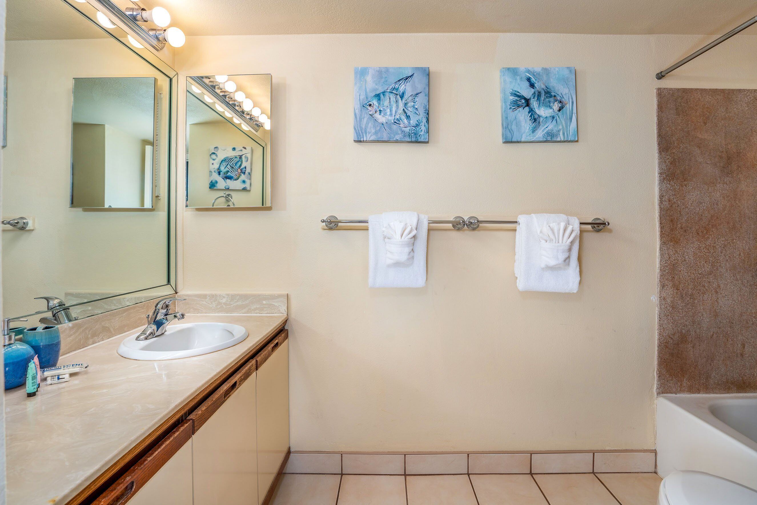 A bathroom with two sinks, a large mirror, and two wall-mounted towels.