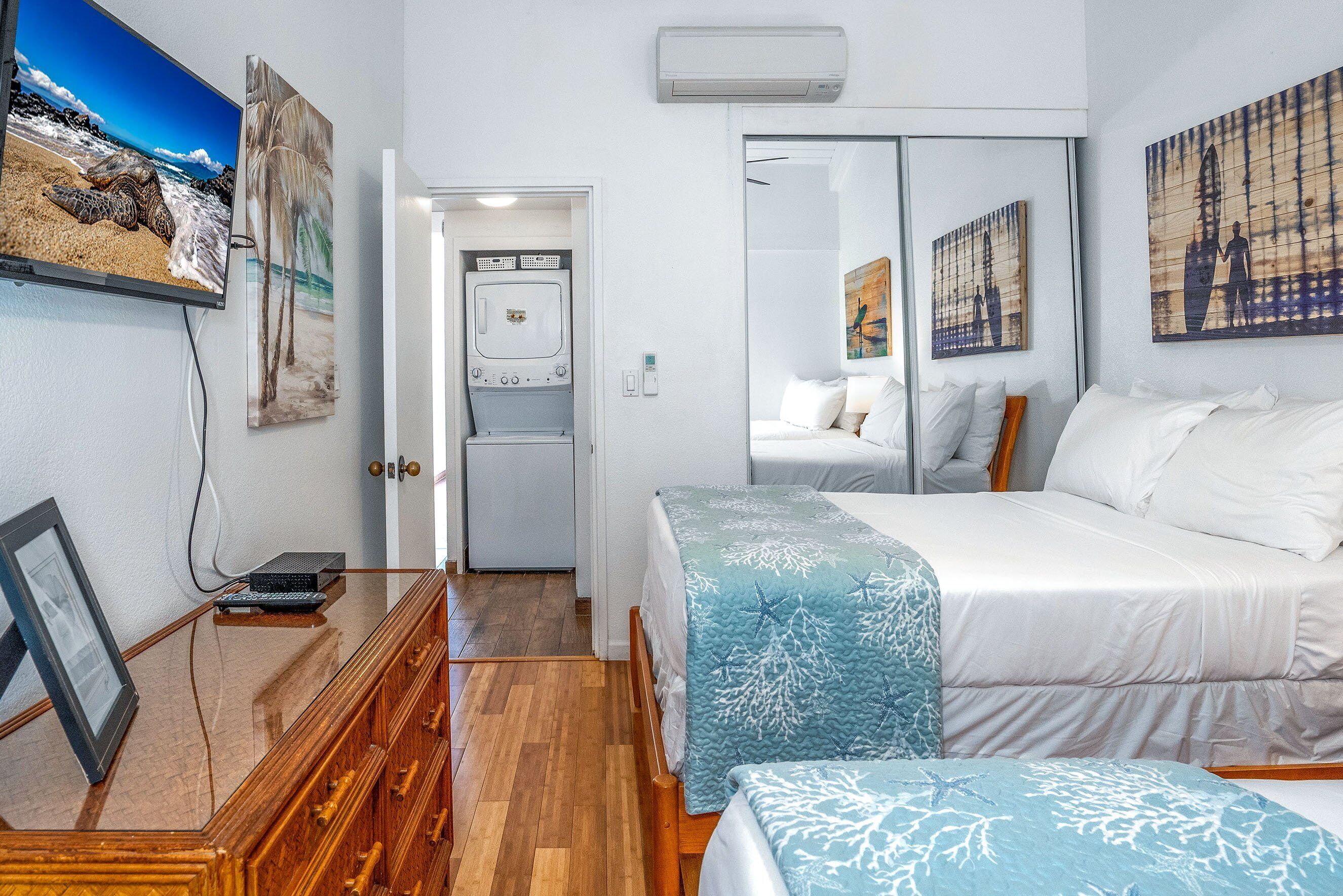 Hotellihuone, jossa on sänky, työpöytä, vaatekaappi ja seinälle asennettu televisio.