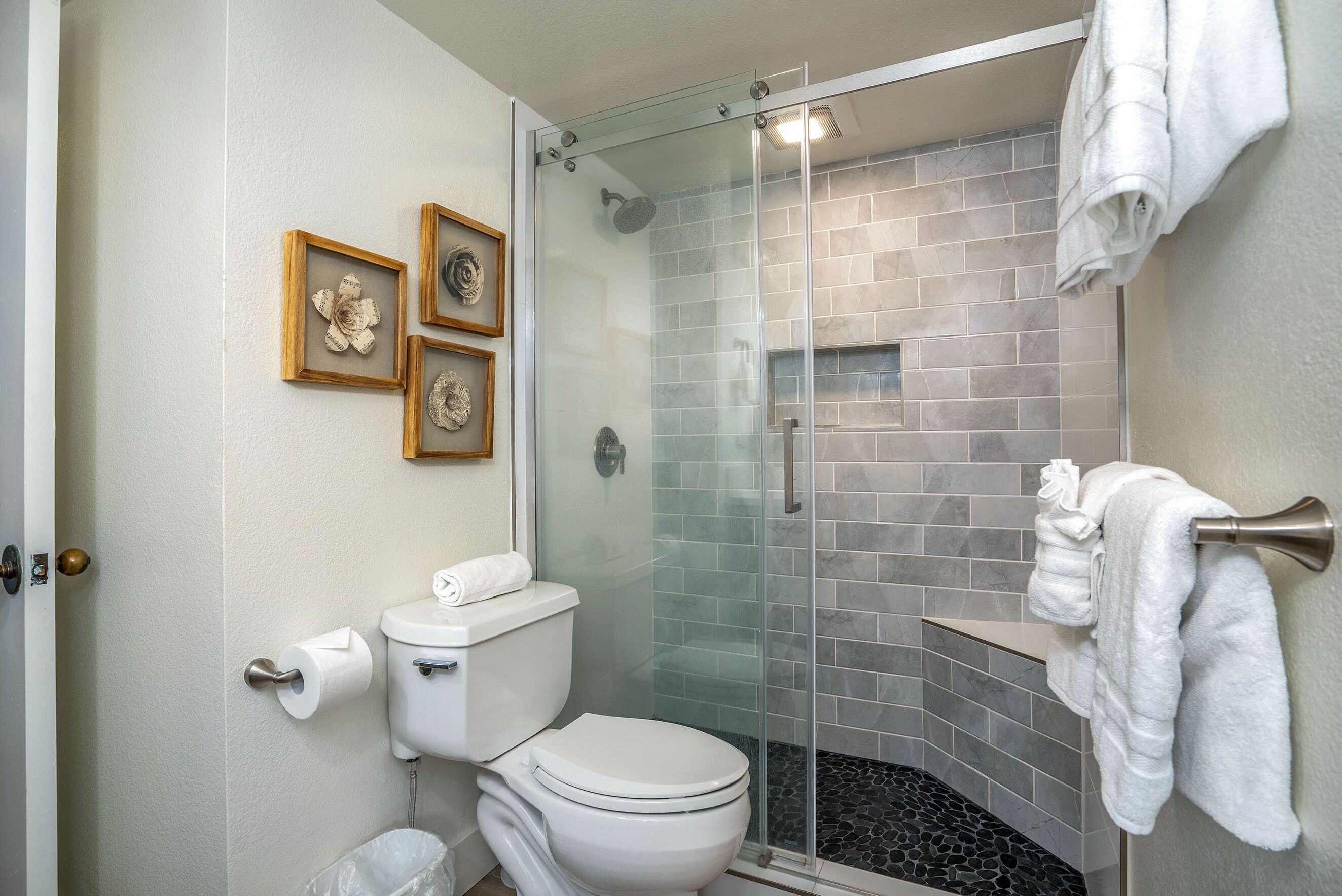 A bathroom with a toilet, a glass shower enclosure, and a towel rack.