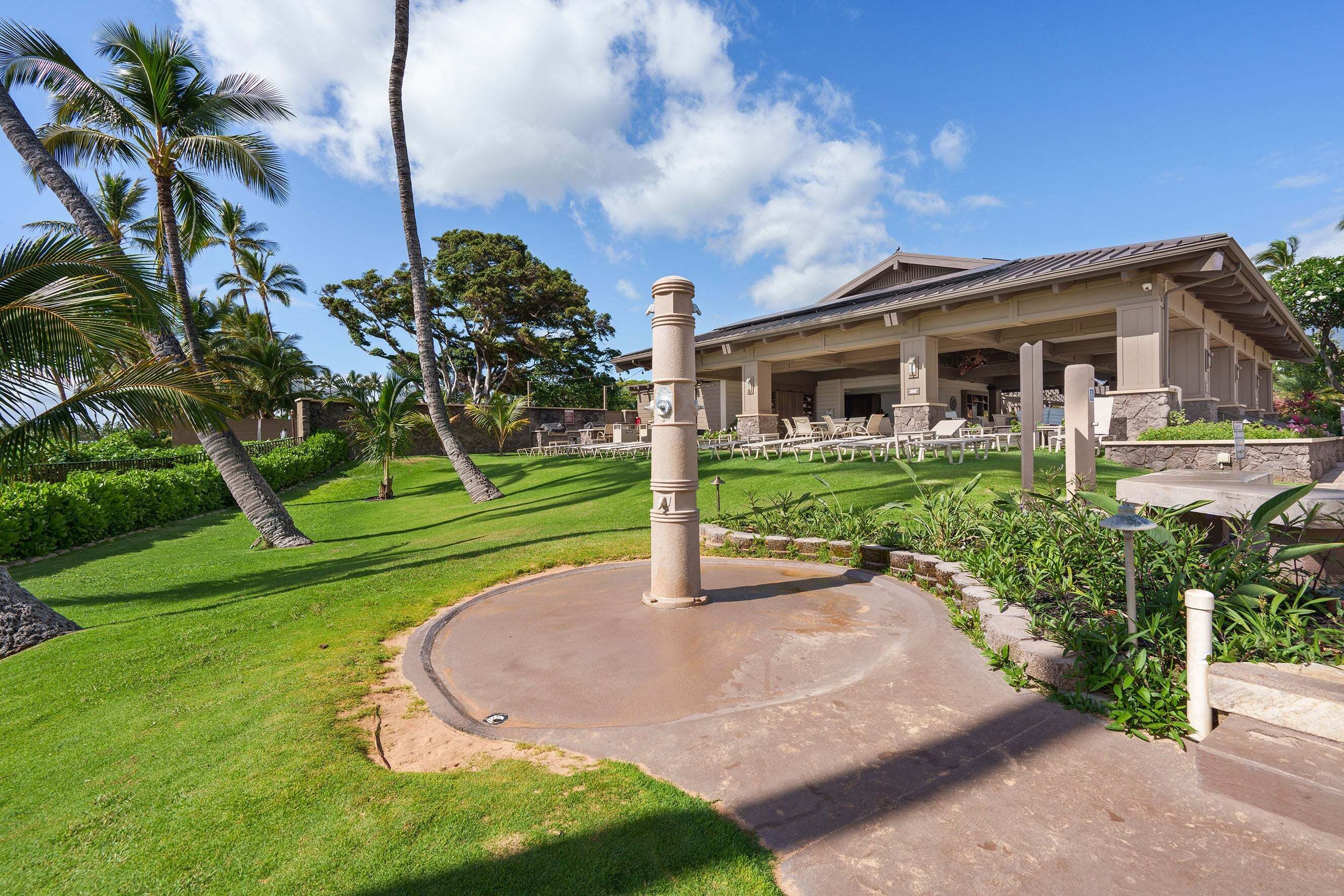 A resort with a large building, palm trees, and a circular concrete area with steps.