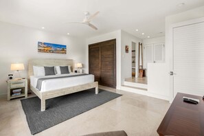 A bedroom with a bed, bedside tables, a ceiling fan, a painting, and a wardrobe. - Wailea Elua 803 - Ocean Views, Modern Renovation, Central AC, Wi-fi, BBQ Grill (Kihei)