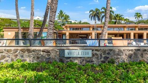 Hotellissa on kivimuuri, palmuja ja kyltti, jossa lukee: ”WAILEA ELUA”.