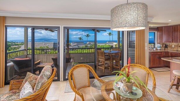 A spacious balcony with a view of the ocean, wicker furniture, and a modern kitchen. - Dramatic Ocean Views, Wailea Ekolu 407, Perfect for Couples, Renovated, Split AC (Kihei)
