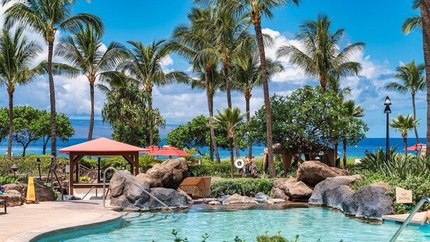 A pool area with palm trees, a gazebo, and a view of the ocean. - Honua Kai Hokulani 934, Renovated, AC, Large Lanai, No Carpet, Amazing Views! (Lahaina)
