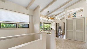 A spacious interior with a high ceiling, a staircase, a dining area, and a kitchen. - Wailea Ekolu 1514 - Ocean Views, Private Lanais, Spacious 2-story in Beautiful Wailea (Kihei)