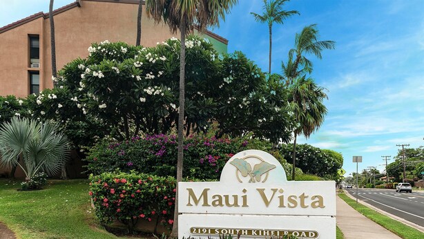 Skilt for 'Maui Vista' på 2191 South Kihei Road, omgivet af frodig vegetation og palmer.