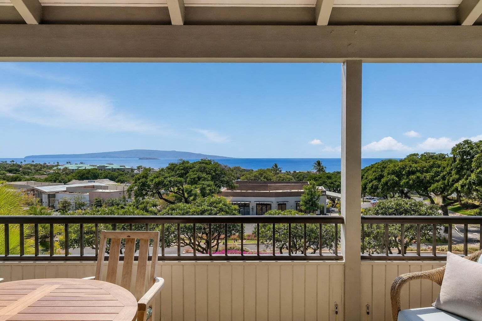 Ein Balkon mit Blick auf eine Küstenlandschaft, einschließlich Gebäude und Bäume.