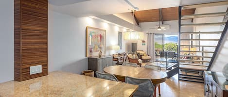 A spacious kitchen with granite countertops, a dining area with a large wooden table, and a view of the outdoors through a sliding glass door.