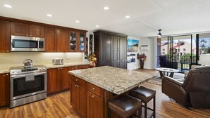 Una cocina moderna con armarios de madera, electrodomésticos de acero inoxidable y encimera de granito.