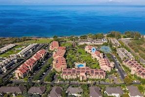 A coastal resort with multiple buildings, a swimming pool, and a view of the ocean. - Kamaole Sands 2-204 - Dramatic Ocean and Courtyard Views, 1bd / 2ba, AC, Wi-fi (Kihei)