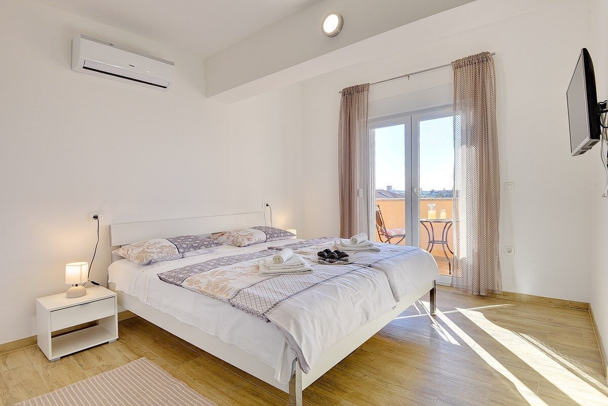 Ein Schlafzimmer mit Bett, Nachttisch und Klimaanlage.