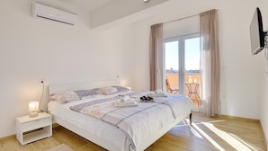 Une chambre à coucher comprenant un lit, une table de chevet et un appareil de climatisation.