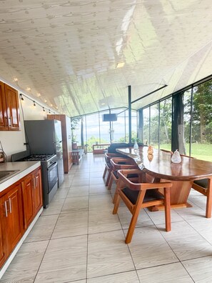 Una cocina moderna con comedor, ventanas amplias y televisor.