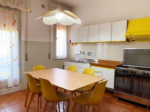 Een koelkast, een oven, kookgerei, borden en bestek