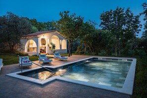 A pool area with lounge chairs and a small building with arched windows. - Villa Laura Medulin (74239-K1) - Medulin (Medulin)