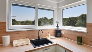 Een koffiezetapparaat/waterkoker, een koelkast, een kookplaat