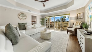 A spacious living room with a white sofa, a round coffee table, and a ceiling fan. - Sandy Ridge Retreat Just Steps from the Splash Pad (Kissimmee)