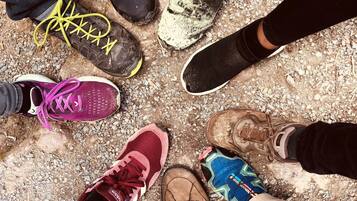 Un groupe de personnes se tient en cercle, chacune portant un type de chaussures différent.