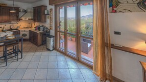 Una cocina con armarios de madera, una mesa de comedor y vistas a través de amplios ventanales correderos.