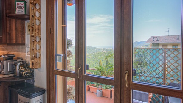 Una cocina con vistas a un jardín y colinas.