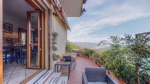 Un patio al aire libre con comedor, zona de estar y plantas en macetas.