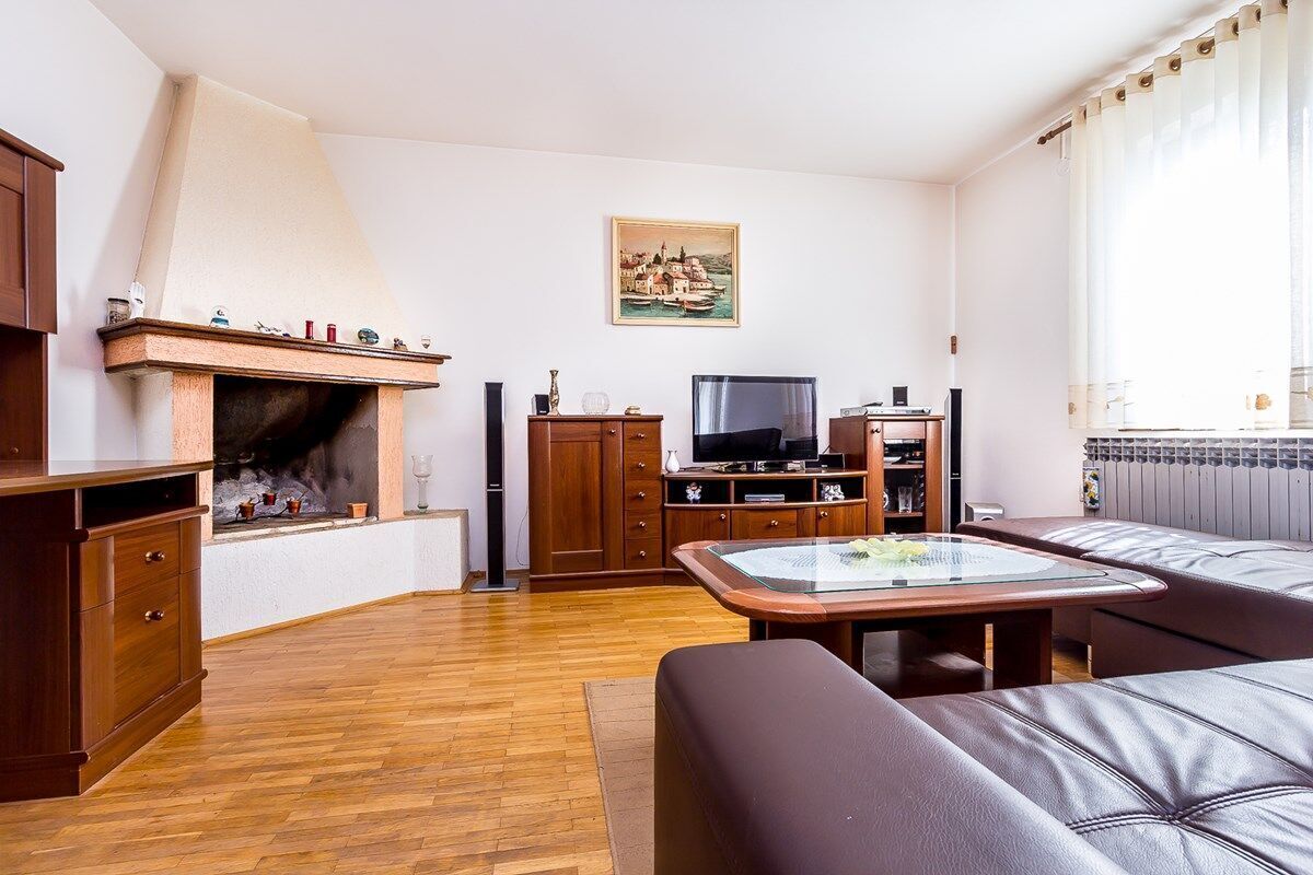 Un salon avec une cheminée, des meubles en bois, un téléviseur et un canapé.