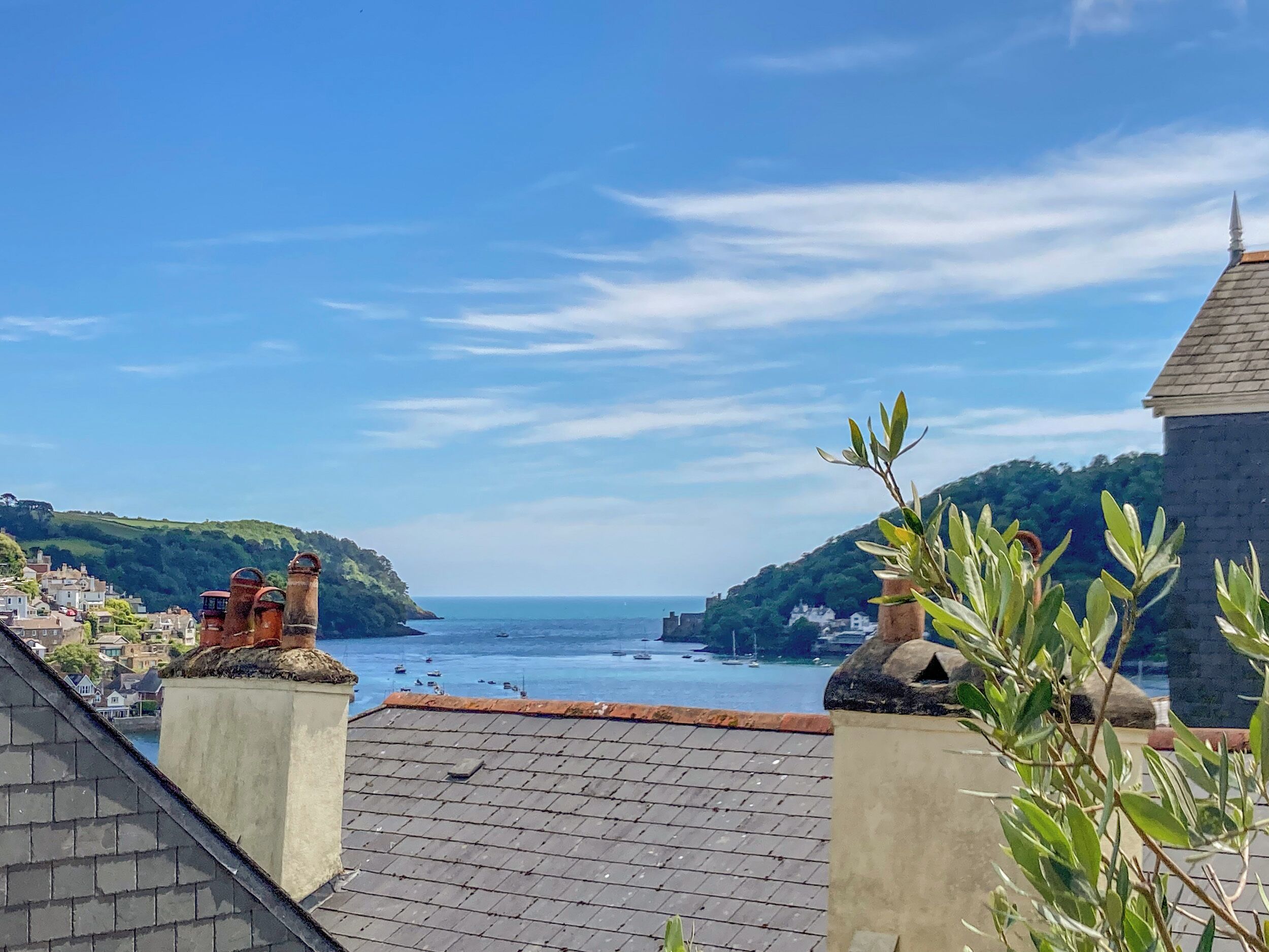 A coastal town with terraced houses, a clear sky, and a view of the sea.
