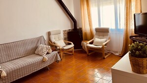 A living room with a sofa, two armchairs, a television, and a fireplace. - Family-friendly house with Garden, 4 Minutes from the Beach (Cambrils)