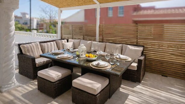An outdoor patio with a large dining table, cushioned seating, and a pergola overhead. - Family-friendly house with Garden, 4 Minutes from the Beach (Cambrils)