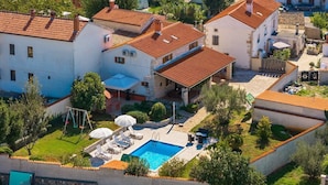 Una zona residenziale con piscina, area relax all'aperto e giardino.