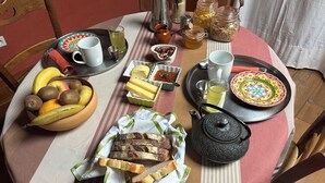 A breakfast table with a variety of food items, including bread, fruits, and condiments. - A B&B in the heart of Chalet Mitja, calm and well-being guaranteed! (La Cabanasse)