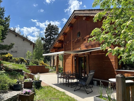 Una baita di legno con patio, posti a sedere all'aperto e un giardino.. A B&B in the heart of Chalet Mitja, calm and well-being guaranteed!