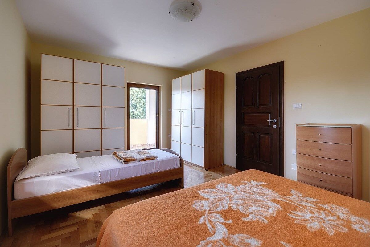 A bedroom with a bed, a dresser, and a wardrobe.
