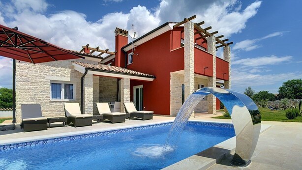 Ein modernes Haus mit Swimmingpool, Sitzgelegenheit im Freien und einer Pergola.