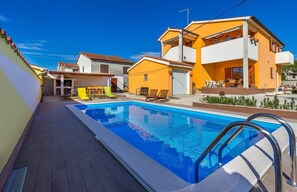 A residential area with a swimming pool, yellow and white houses, and outdoor seating. - Villa Ninetta (V3581-K1) - Vodnjan (Vodnjan)