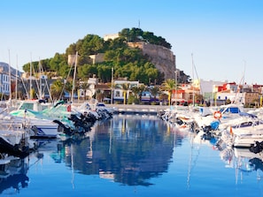 A marina with boats docked, a clear sky, and a hill with a fort in the background. - Wunderschöne Villa in Dénia mit privatem Pool by Interhome (Dénia)