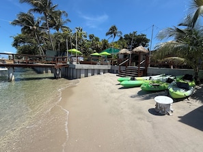 Een privéstrand, ligstoelen aan het strand, parasols, duiken